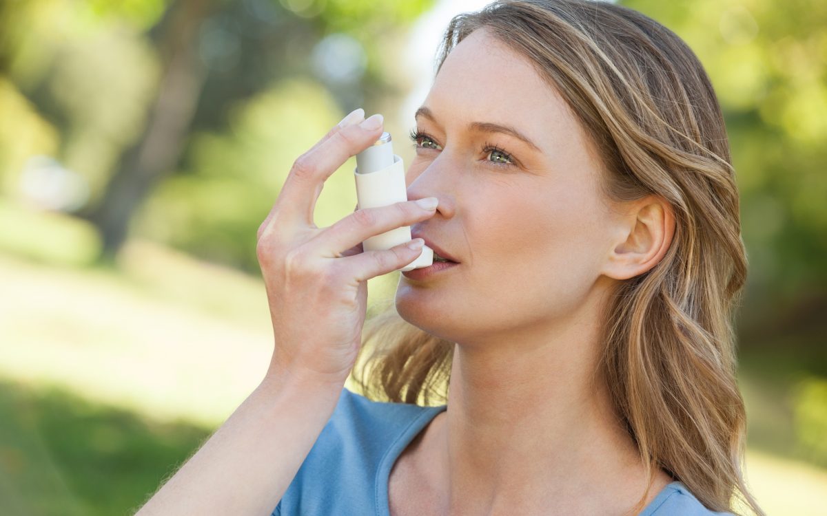 Woman using asthma inhaler